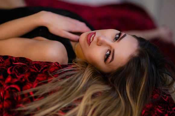 Brunette lingerie model lying on red roses