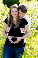 Pregnancy photo of couple making a heart with their hands