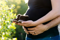 Maternity, expecting couple holding pair of newborn shoes