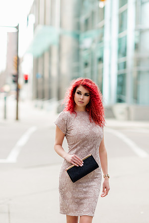 Amber fiery redhead woman model in a beige dress walking down the street in downtown Calgary