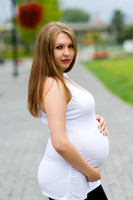 Beautiful pregnant woman walking in the park in the summer