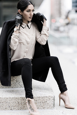 Commercial fashion woman model on top of series of stairs, with jacket over her shoulders