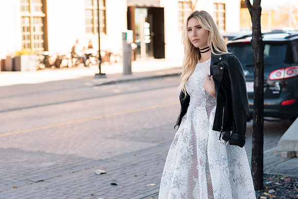 Jewelry Commercial Photo shoot, with blond woman Model wearing a long light blue overcoat, silk white dress, and Made by Jemily choker