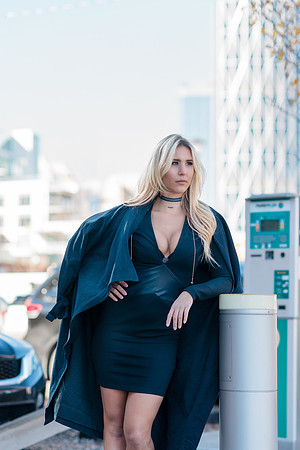Made by Jemily Jewelry Commercial Photo shoot, with blonde woman model wearing a dark blue dress outfit and Made by Jemily choker,with the Bow Tower in Calgary in the background