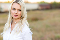 Blonde model in a white blouse in the fall with train in the background