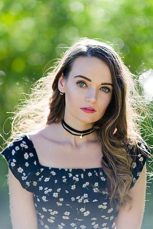Green eyes woman model wearing black choker and black dress portrait