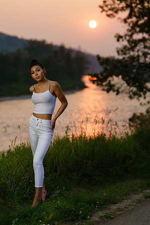 teen woman model with red sunset over river