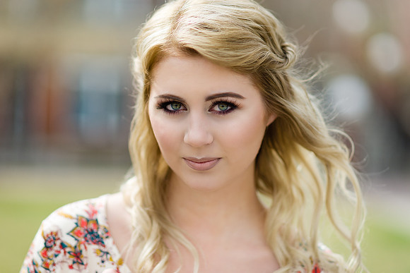 Blonde woman model portrait with green eyes in flowery dress