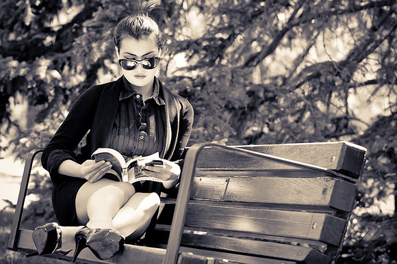 Business Woman reading a book on a bench